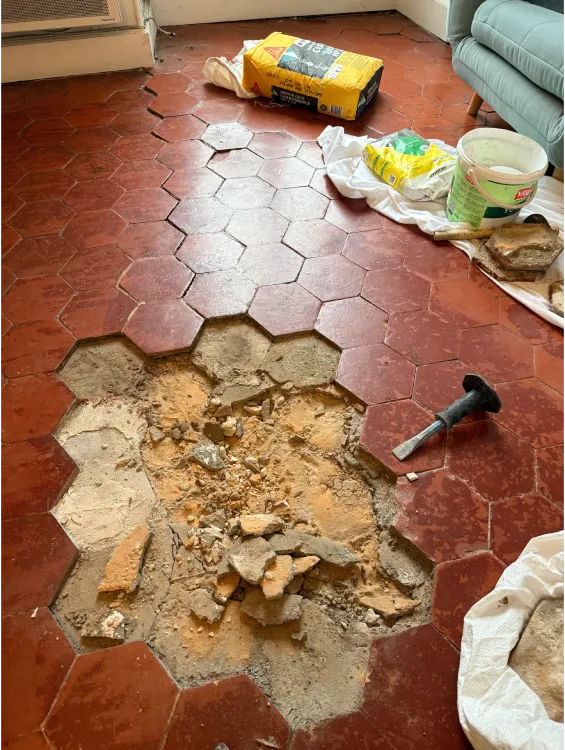 Artisan en cours de dépose des anciennes terres cuites