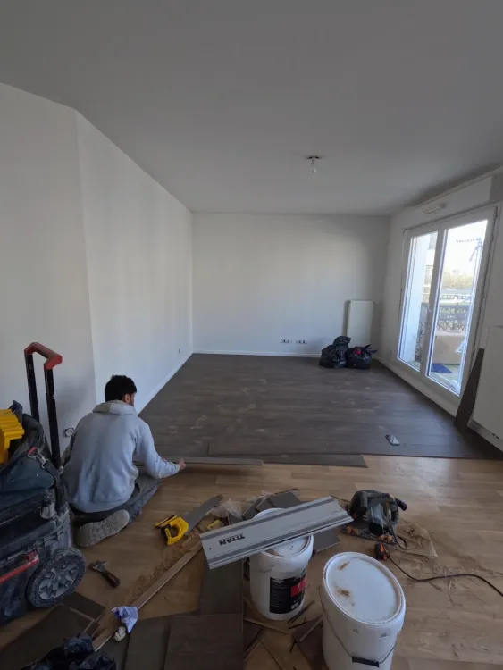 Artisan posant les lames de parquet stratifié
