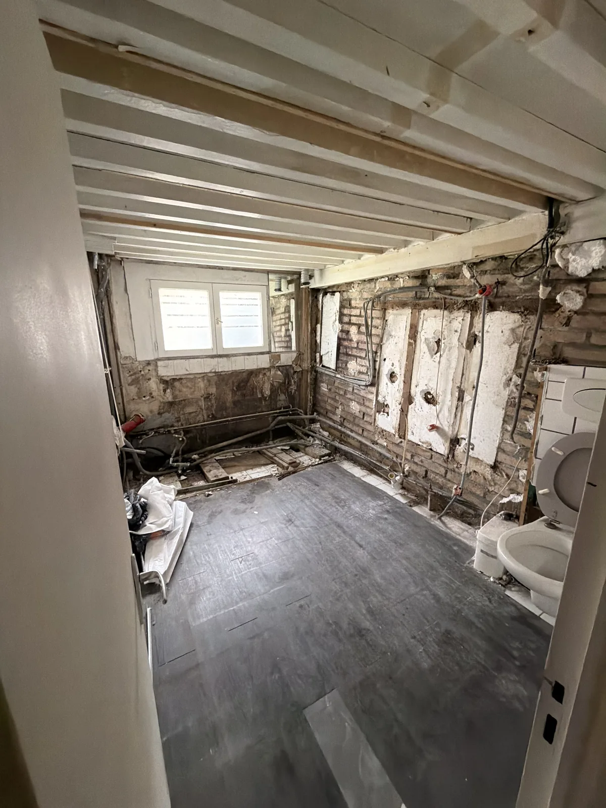 Démolition de la salle de bain à Galluis : faïence et cloisons déposées, murs mis à nu jusqu’à la brique
