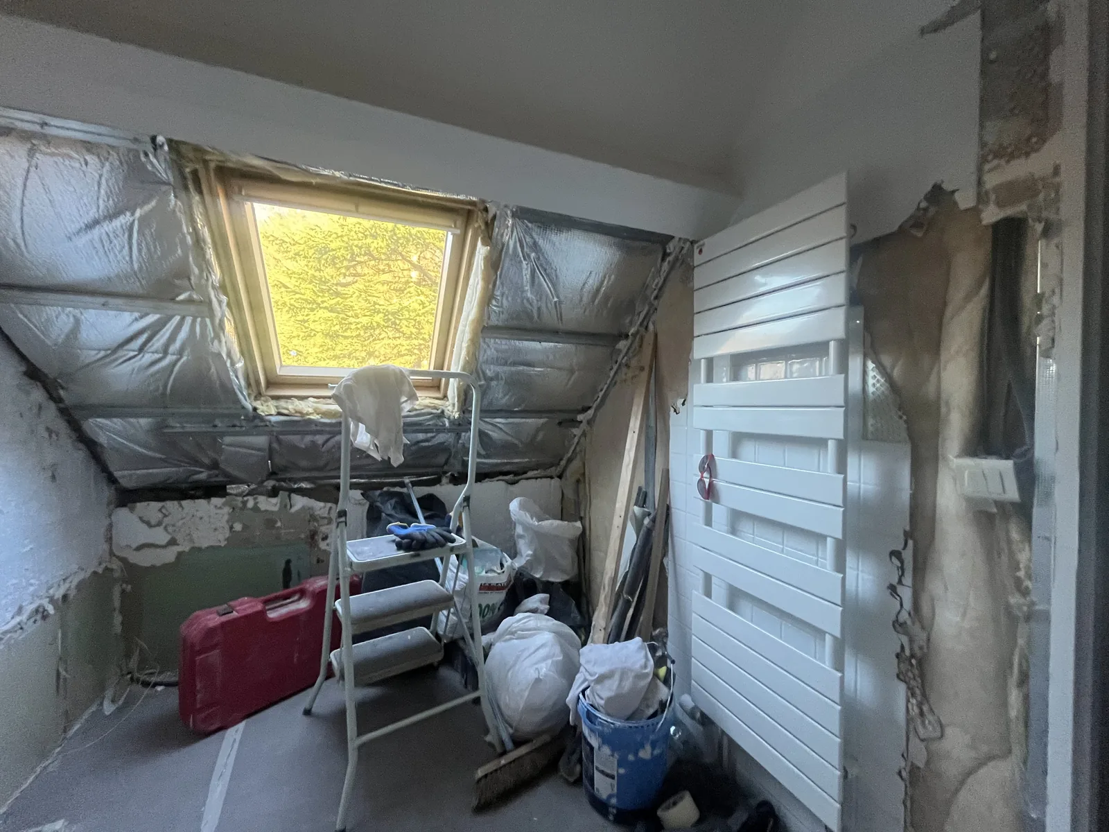 Dépose et démolition de la salle de bains à Grosrouvre : baignoire et faïence retirées, isolation des rampants apparente