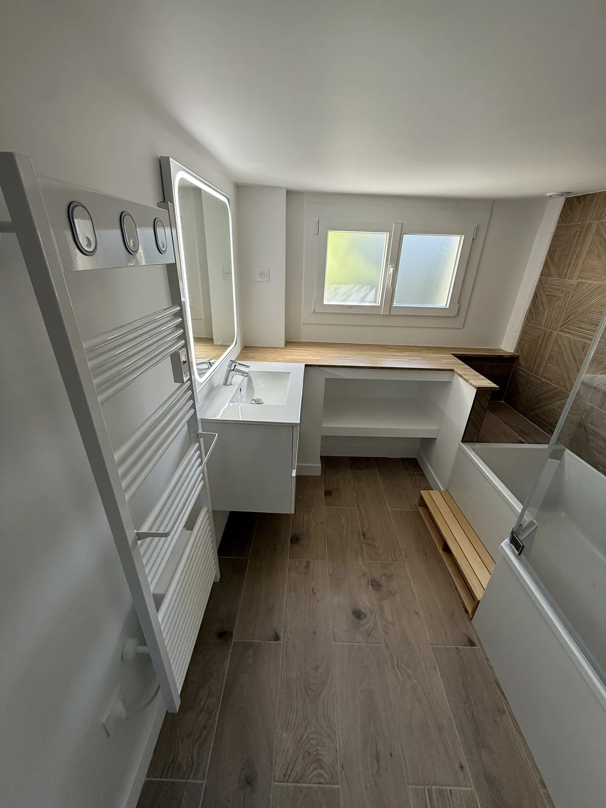 Meuble vasque, miroir éclairant et sèche-serviettes électrique après rénovation de la salle de bain à Galluis