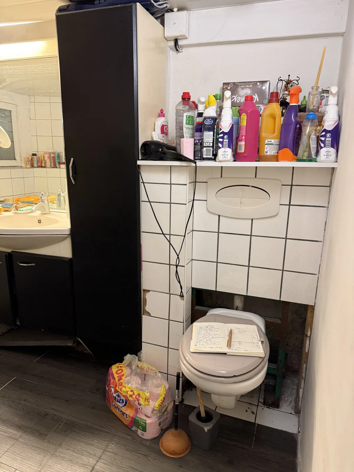 Salle de bain avant travaux à Galluis : WC dans la salle de bain, meuble noir et faïence blanche