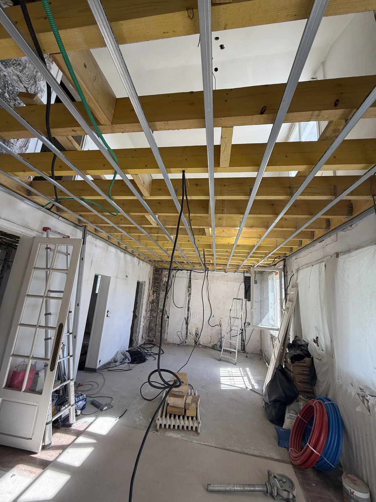 Nouveau solivage en madriers vu du dessous, avec ossature du futur faux plafond, à Palaiseau